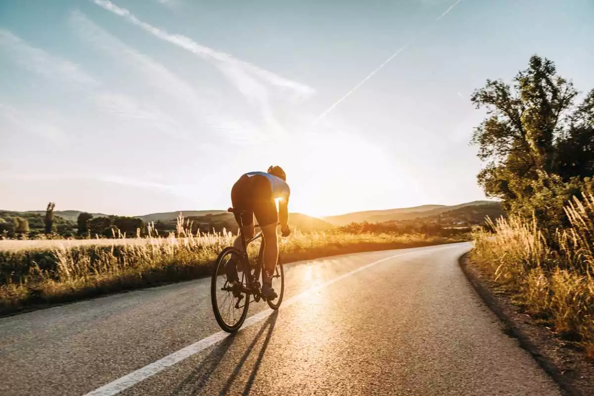 A cyclist pedals his bike through a beautiful natural landscape.