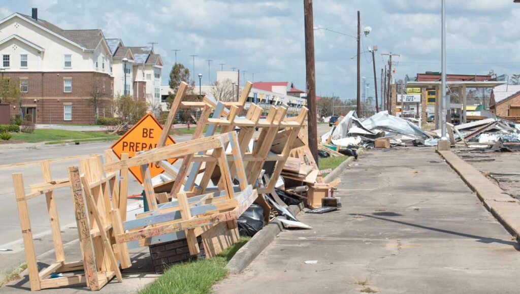 Debris piled up on the side of the street after a hurricane.