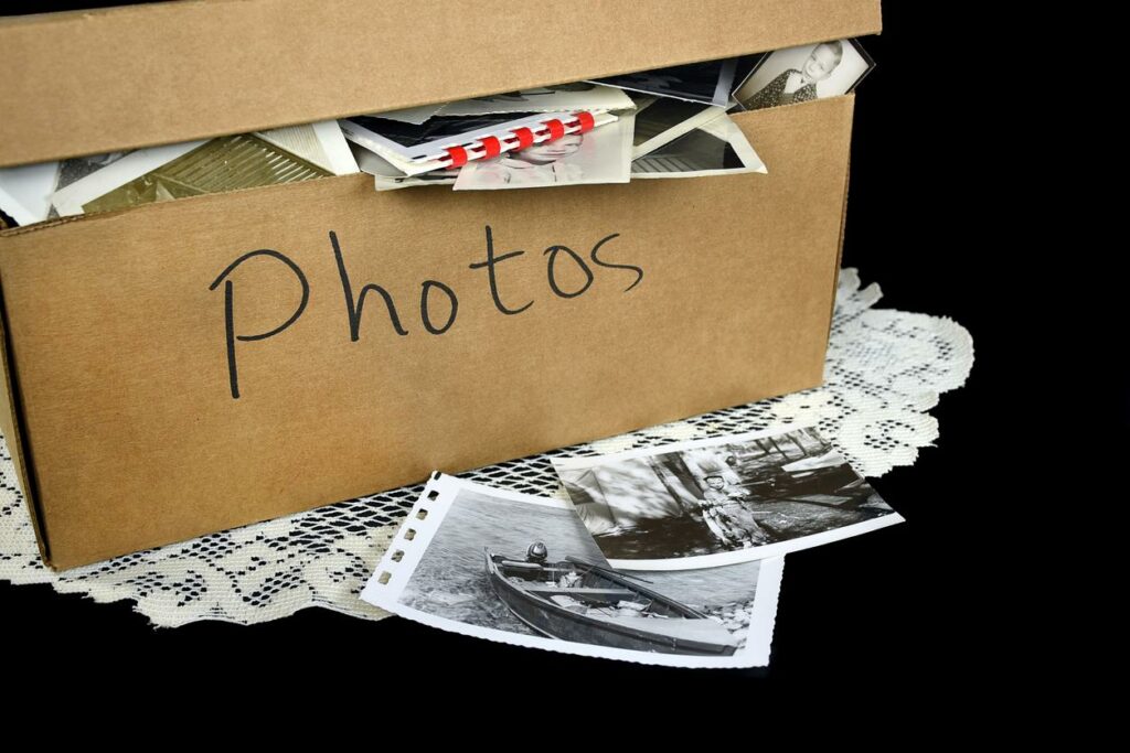 A cardboard box labeled “photos” filled with Polaroid snapshots.